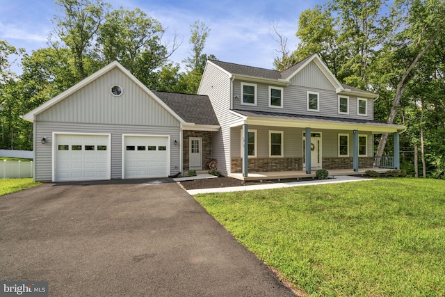 view of front of home with a garage, a front yard, and covered porch