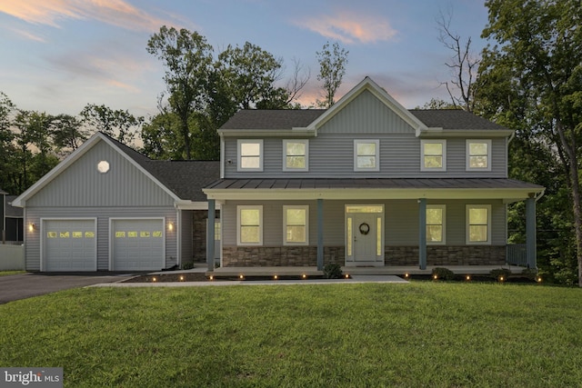 view of front of house with a garage, a porch, and a lawn