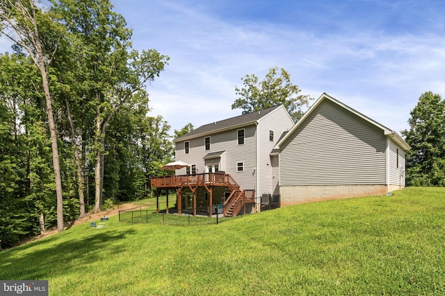 back of house featuring central AC unit, a wooden deck, and a yard