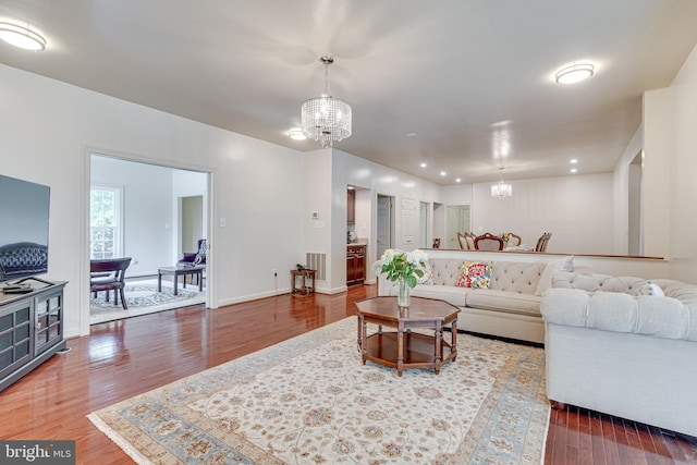 living room with hardwood / wood-style floors and a chandelier