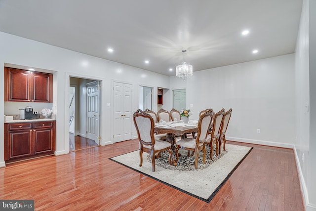 dining room with light wood-type flooring and a chandelier