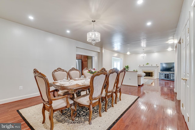 dining space featuring hardwood / wood-style floors and a chandelier