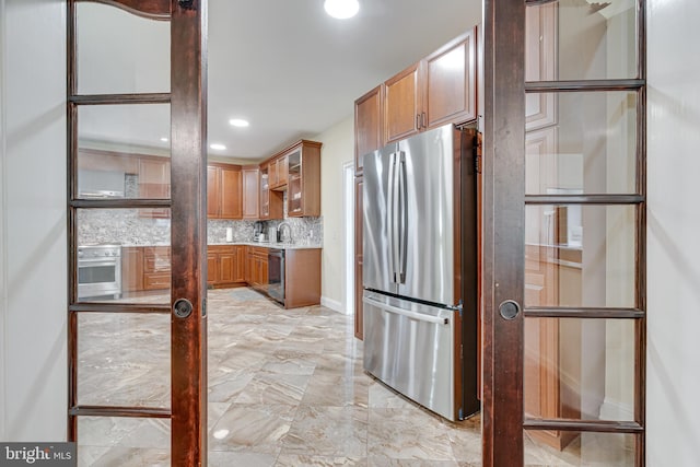 kitchen featuring light tile patterned floors, appliances with stainless steel finishes, sink, and decorative backsplash