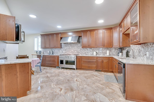 kitchen featuring sink, light stone counters, decorative backsplash, and wall chimney exhaust hood