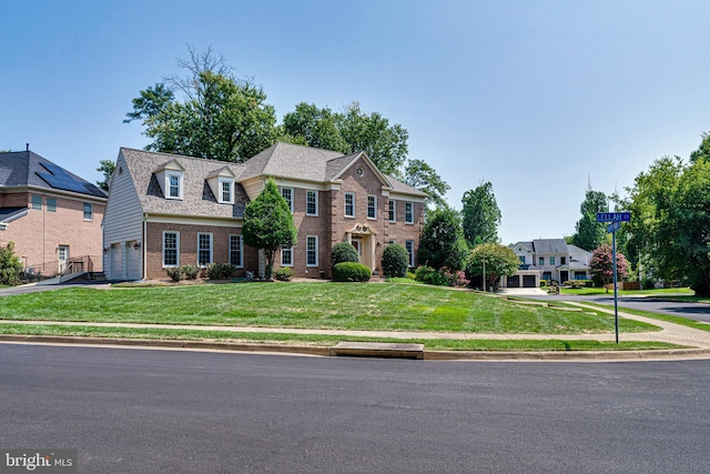 colonial inspired home featuring a garage, solar panels, and a front yard