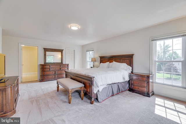 bedroom with multiple windows and light colored carpet