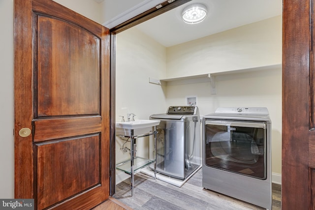 laundry area featuring washer and dryer and light hardwood / wood-style flooring