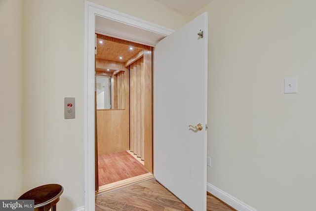 corridor with hardwood / wood-style flooring