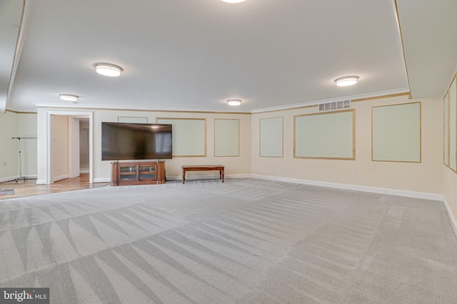 unfurnished living room featuring ornamental molding and carpet flooring