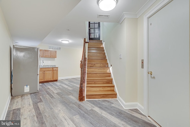 stairway featuring crown molding and wood-type flooring