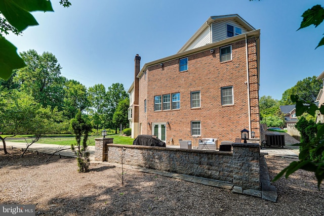 rear view of house with cooling unit and a patio