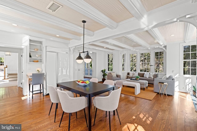 dining area with light wood-type flooring, beam ceiling, visible vents, and crown molding