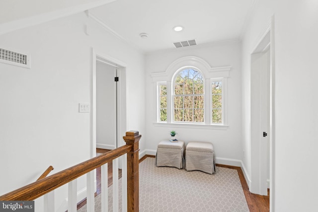 bedroom with baseboards, visible vents, wood finished floors, and ornamental molding