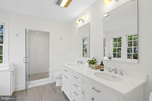 bathroom with double vanity, a sink, toilet, and a shower stall