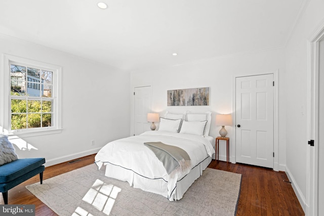 bedroom with visible vents, baseboards, dark wood finished floors, and recessed lighting