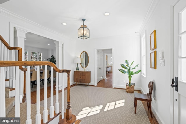 foyer with baseboards, crown molding, ornate columns, and stairs