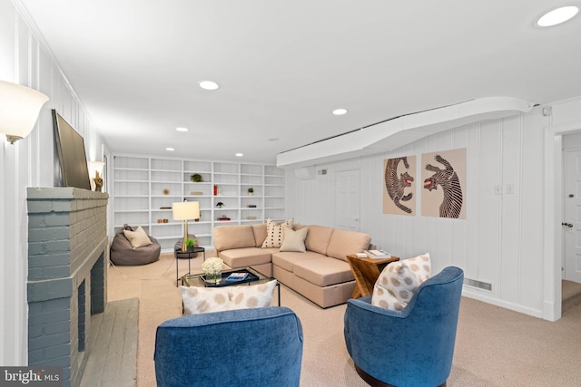 living area with recessed lighting, visible vents, and a fireplace