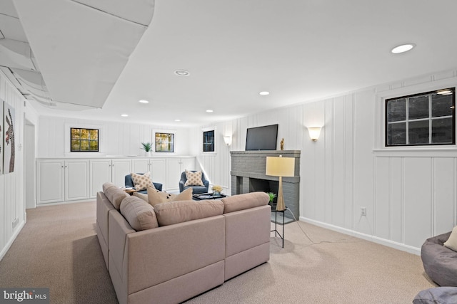 carpeted living room featuring a decorative wall, a fireplace, and recessed lighting