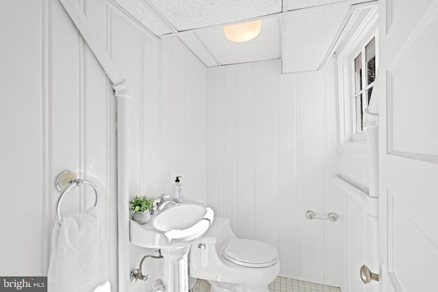 bathroom featuring toilet and a drop ceiling