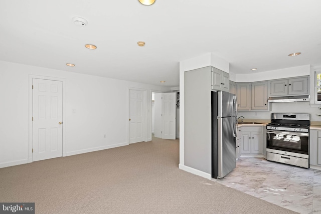 kitchen with baseboards, under cabinet range hood, appliances with stainless steel finishes, and gray cabinetry