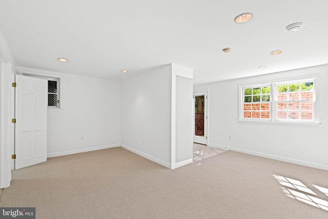 spare room featuring baseboards, recessed lighting, and light colored carpet