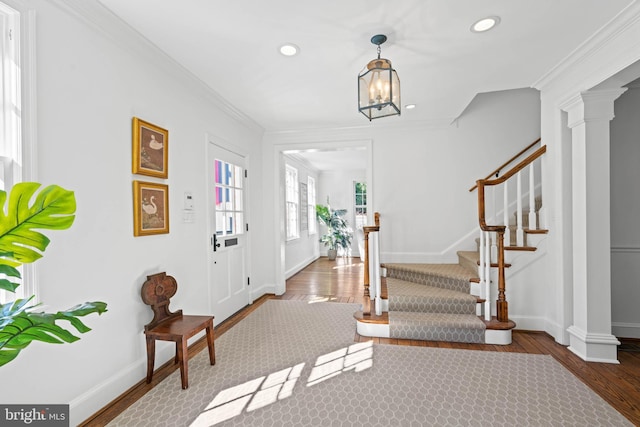 entrance foyer featuring baseboards, ornamental molding, wood finished floors, and recessed lighting