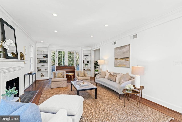 living room featuring baseboards, a fireplace, visible vents, and ornamental molding