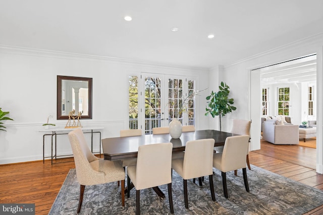 dining space featuring ornamental molding, hardwood / wood-style floors, and french doors