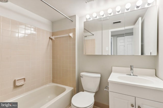 full bathroom featuring tiled shower / bath combo, toilet, and vanity