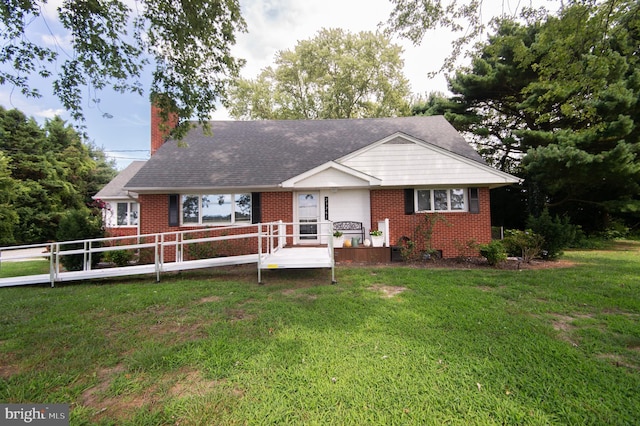 ranch-style house with brick siding, a chimney, a front yard, and fence