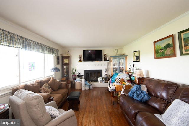 living room featuring crown molding, a brick fireplace, and dark hardwood / wood-style floors