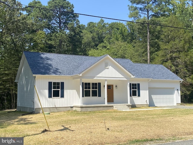 modern farmhouse style home featuring a garage, a front yard, a porch, and roof with shingles