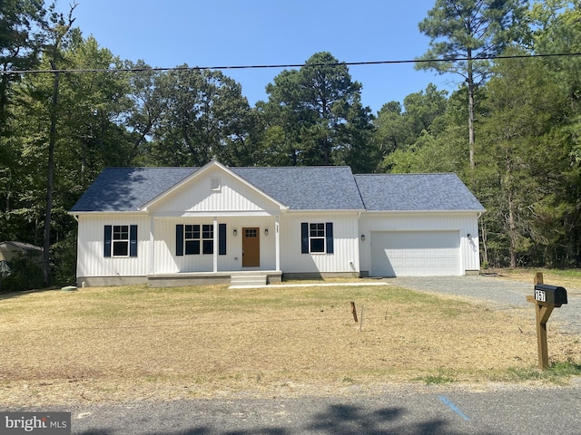 modern farmhouse style home with a garage, gravel driveway, a shingled roof, and a porch