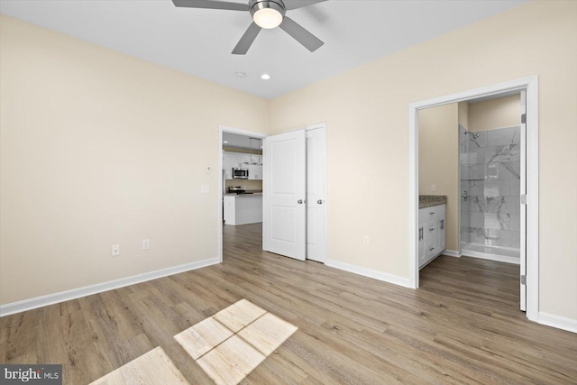 unfurnished bedroom with connected bathroom, light hardwood / wood-style flooring, and ceiling fan