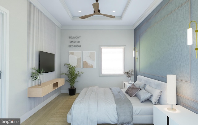 bedroom featuring ceiling fan, ornamental molding, a tray ceiling, and light hardwood / wood-style flooring