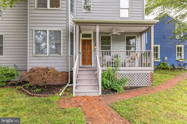 property entrance featuring ceiling fan, covered porch, and a yard