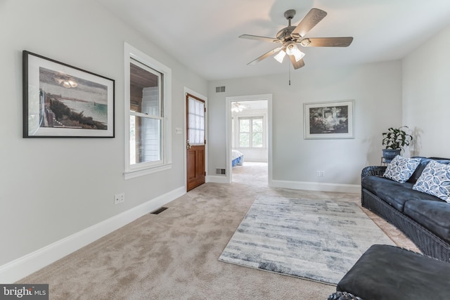 carpeted living room featuring ceiling fan