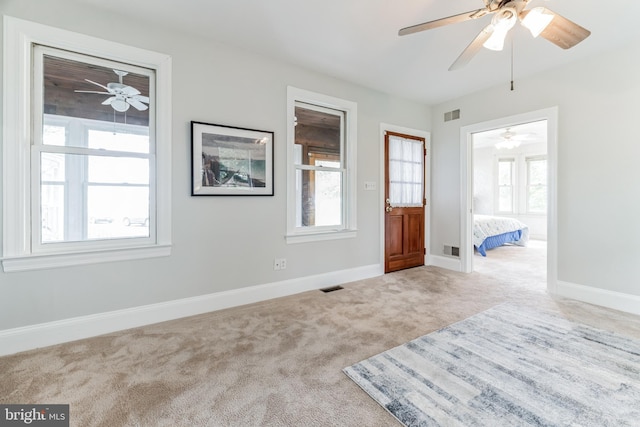 carpeted bedroom featuring ceiling fan and multiple windows