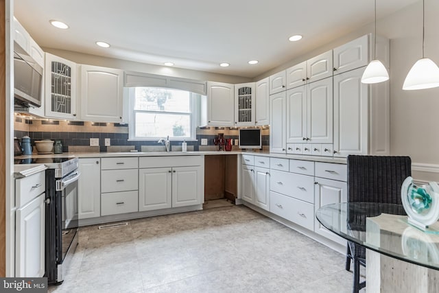 kitchen with tasteful backsplash, light tile patterned flooring, stainless steel appliances, and decorative light fixtures