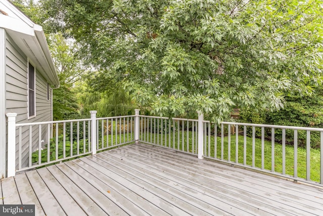 wooden terrace featuring a lawn