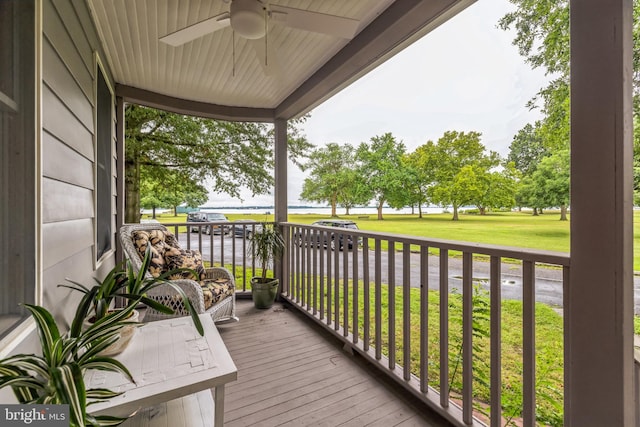 wooden deck with ceiling fan and a lawn