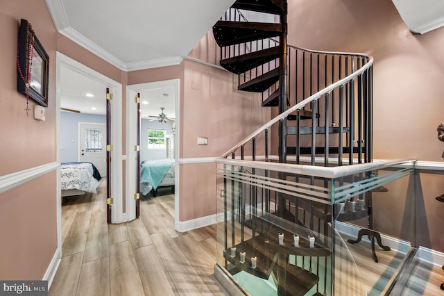 stairs featuring wood-type flooring and ornamental molding