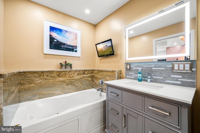 bathroom with vanity, backsplash, and a bathing tub