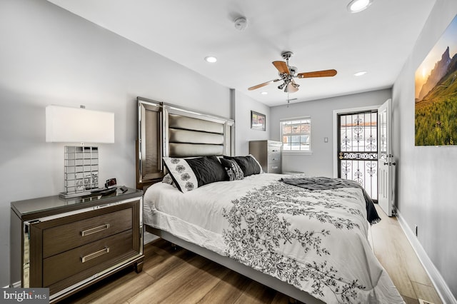 bedroom with ceiling fan, access to outside, and wood-type flooring