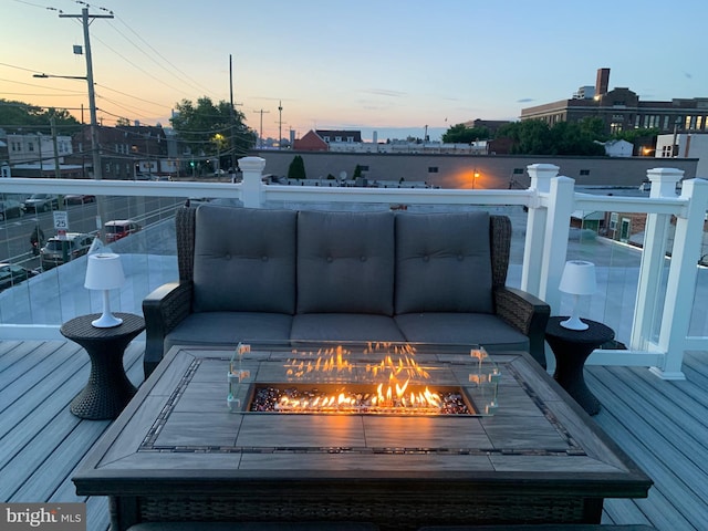 deck at dusk featuring a fire pit