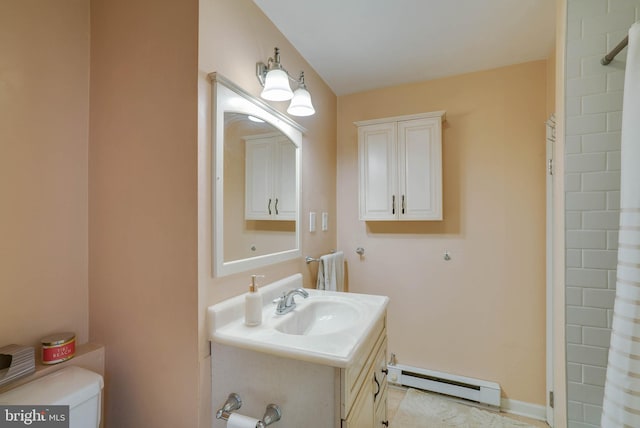 bathroom featuring tile patterned flooring, baseboard heating, vanity, and toilet