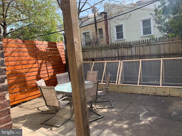 view of patio featuring outdoor dining space and fence