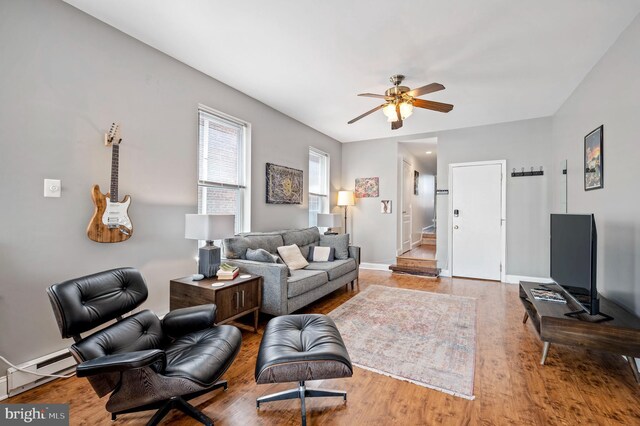 living room with ceiling fan, light hardwood / wood-style floors, and baseboard heating