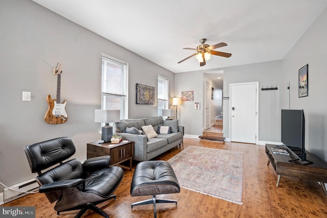 living room with baseboards, ceiling fan, baseboard heating, and wood finished floors