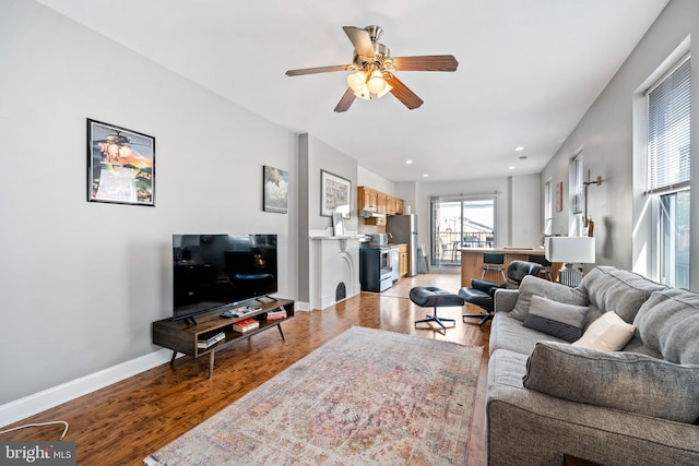 living room with ceiling fan and light hardwood / wood-style flooring